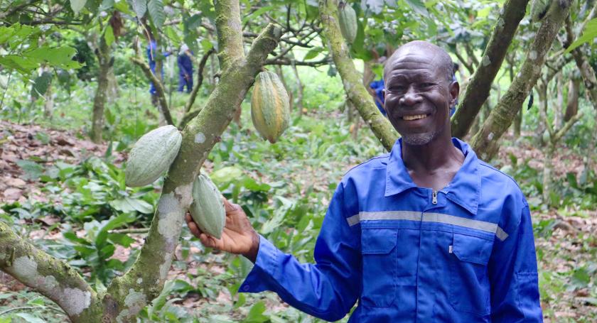 Community Service Group member next to cocoa pods