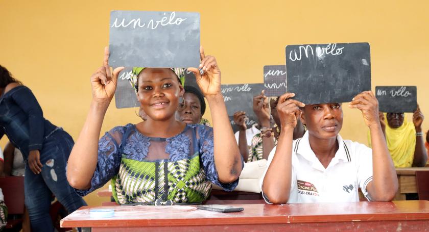 Students sitting in class and raising their blackboards