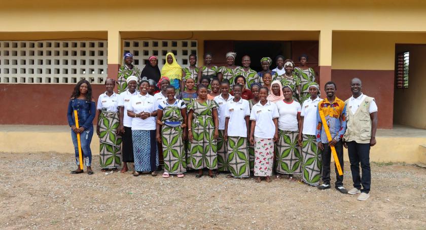 Students and teachers pose in front of school