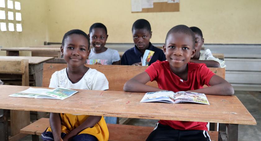 children sitting in class reading books