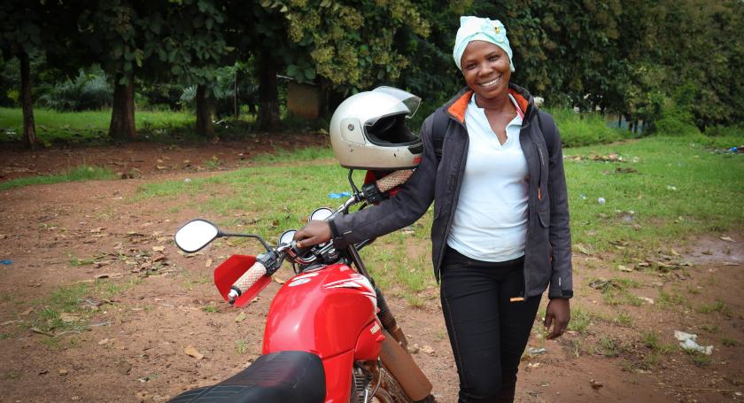 community facilitator poses with her motorbike