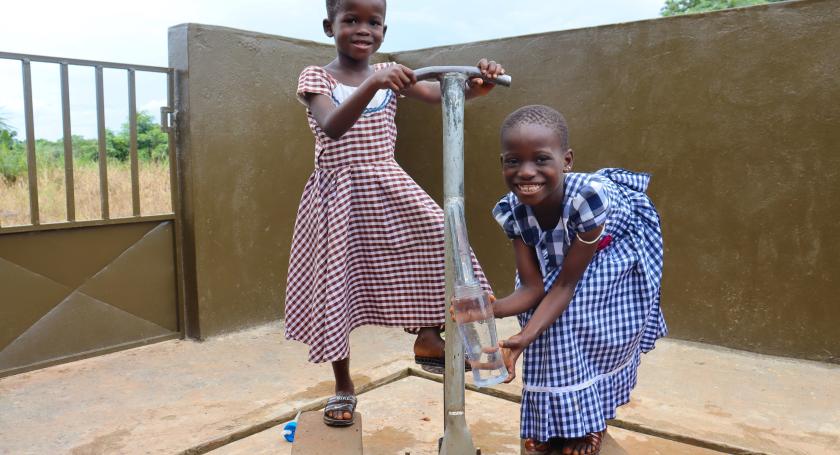 two girls pumping water at new water fountain in school 