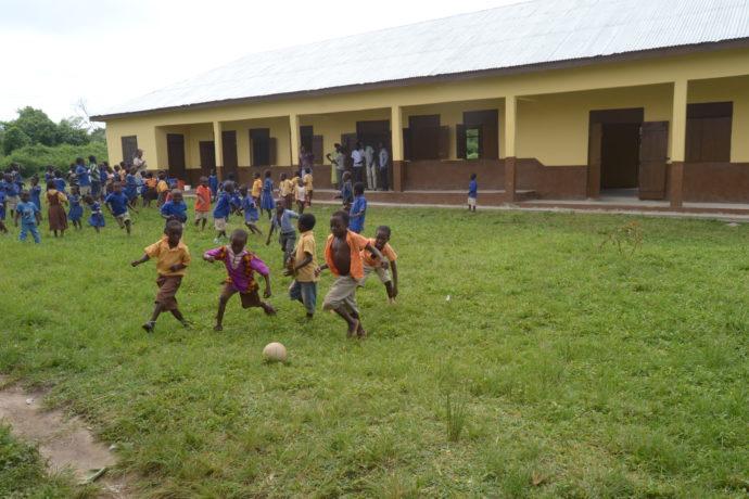 children playing in front of the new school block