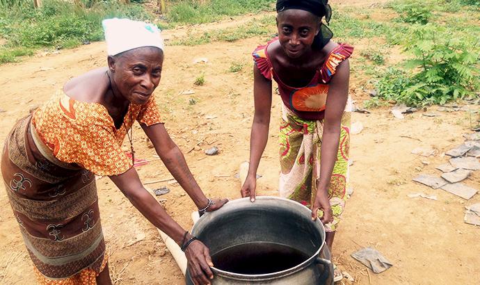 Two women holding a pot with water celebrating Rural Women’s Day
